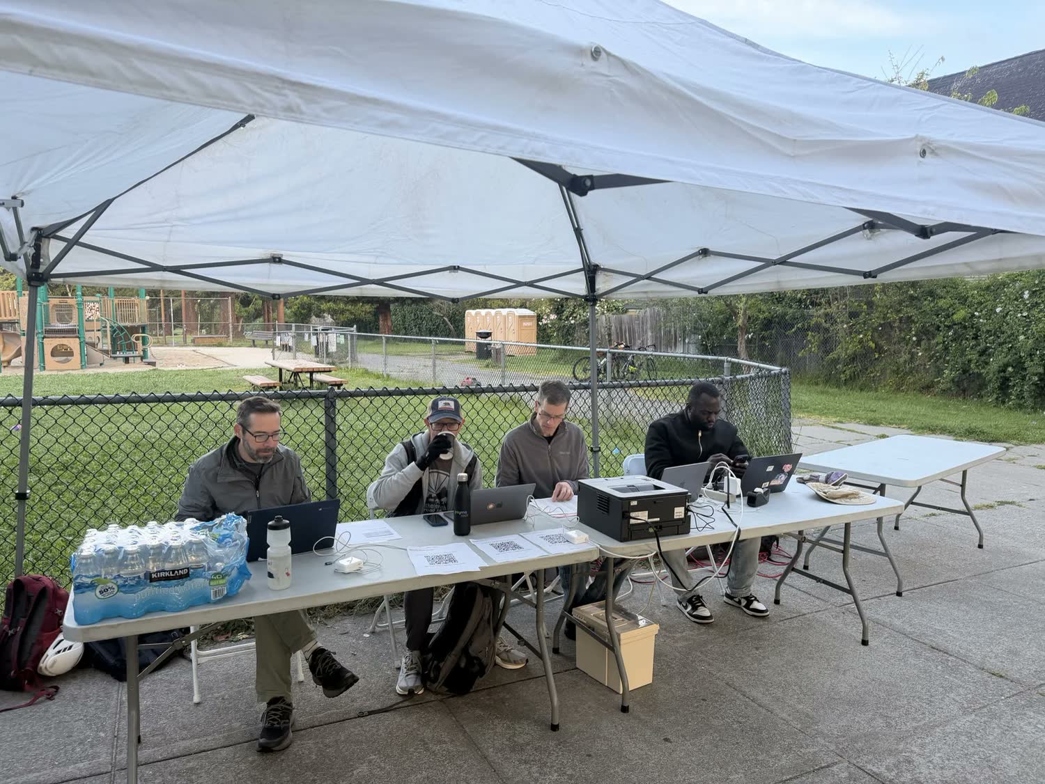 Volunteers at a timing and results table under a canopy