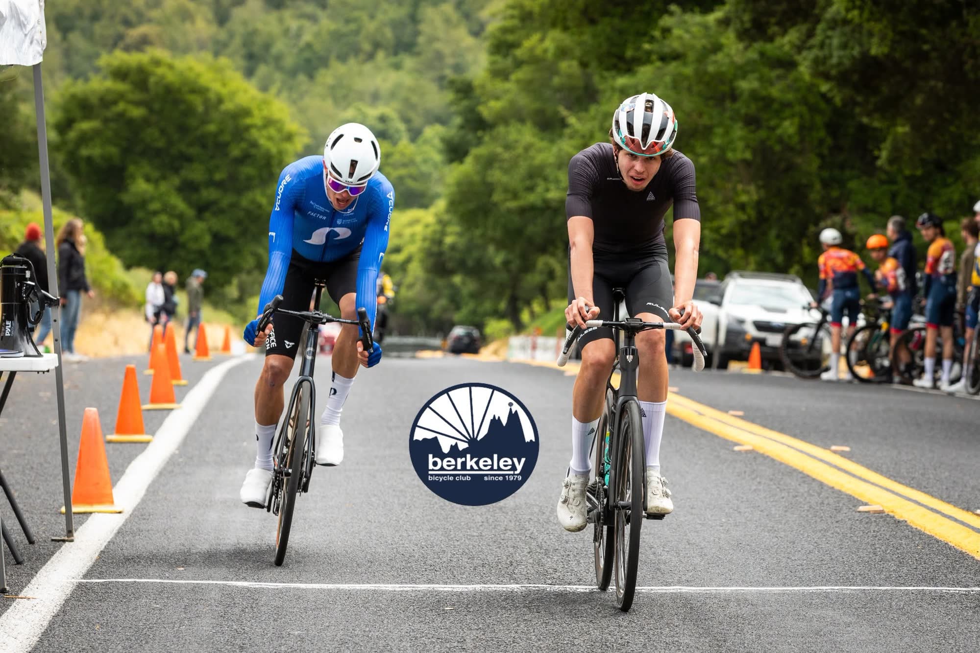 Two riders sprinting side by side for the line, one in blue and one in black