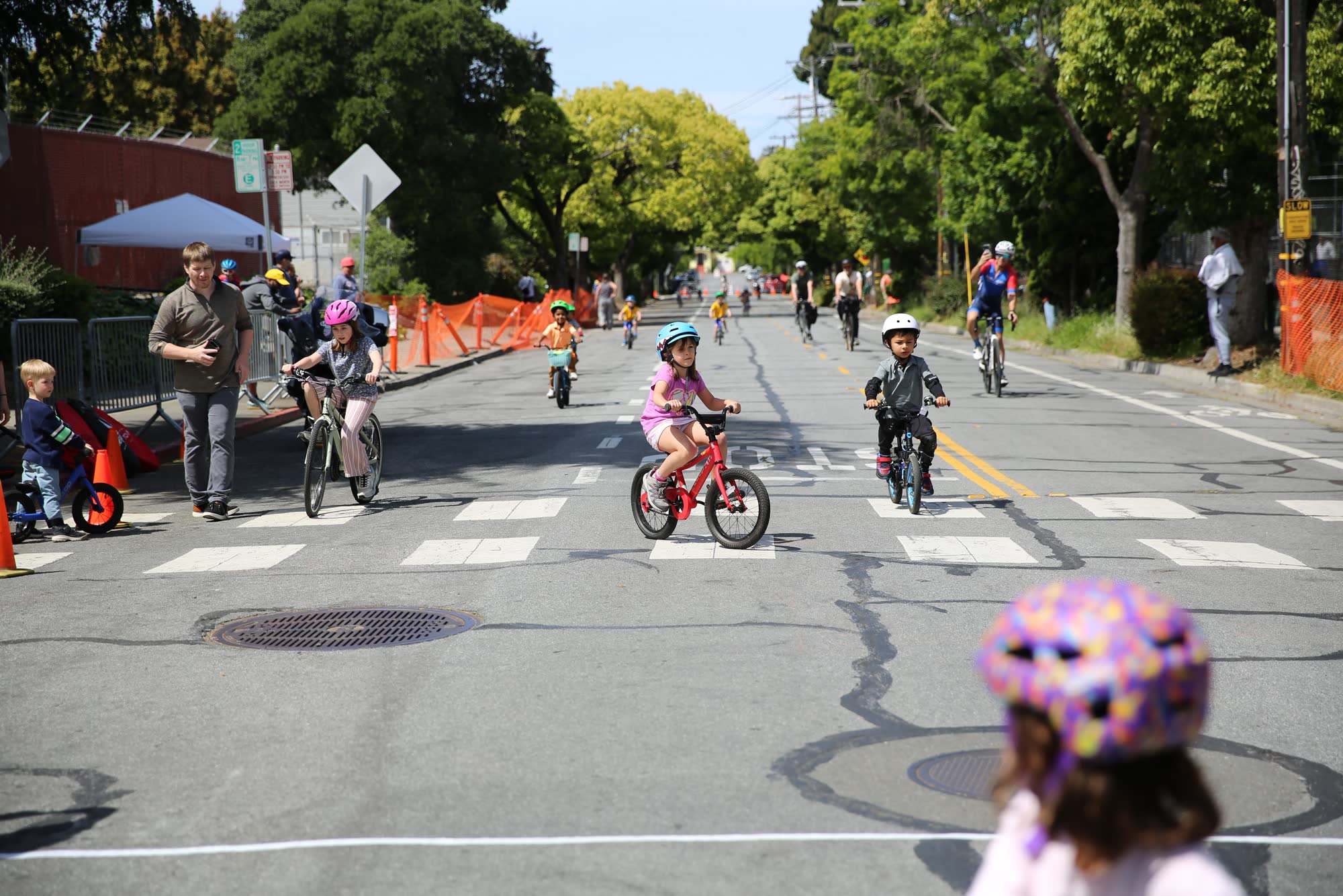 Young riders on the street course during the kids race, with spectators lining the route