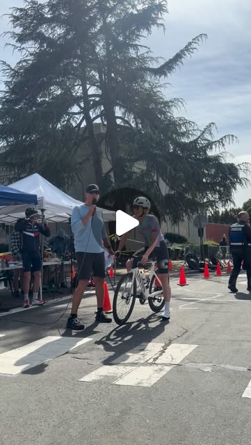 The announcer interviewing a rider on the coned street course at the 2026 Berkeley Omnium