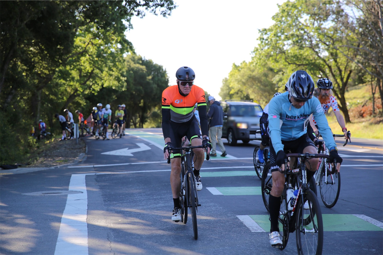 A Berkeley Bicycle Club rider in a light blue club jersey rolls through the start area with other racers at the 2026 Berkeley Hills Road Race