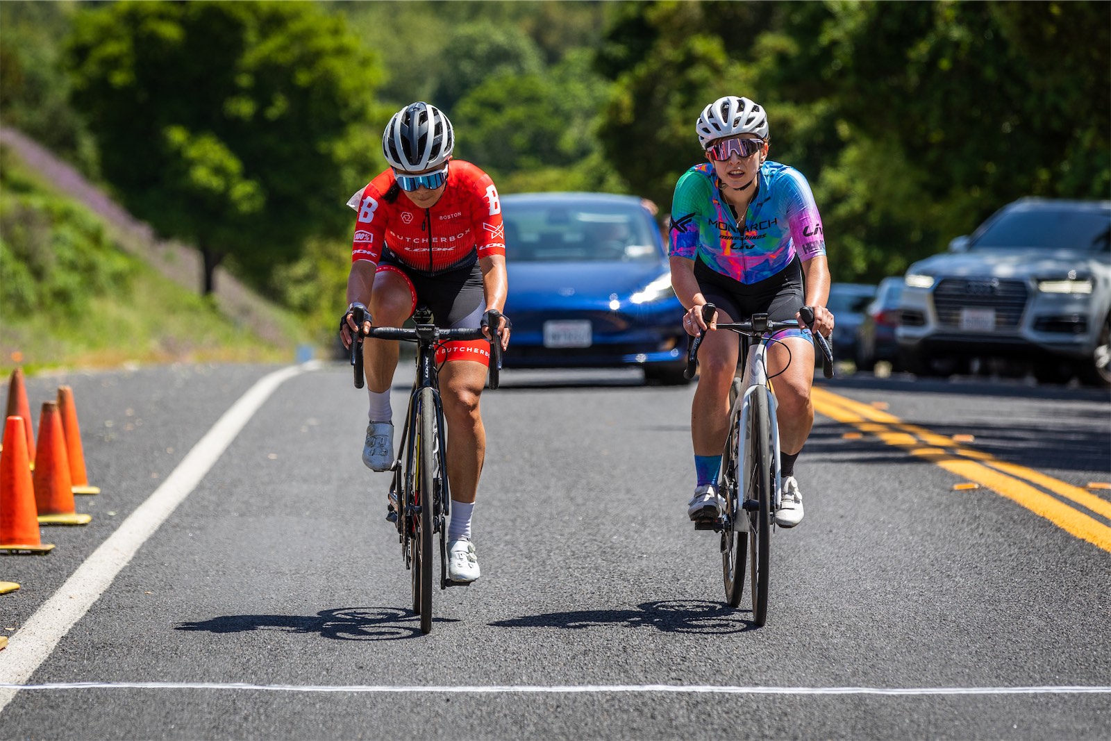 A Monarch Racing rider racing alongside a ButcherBox rider at the Berkeley Omnium
