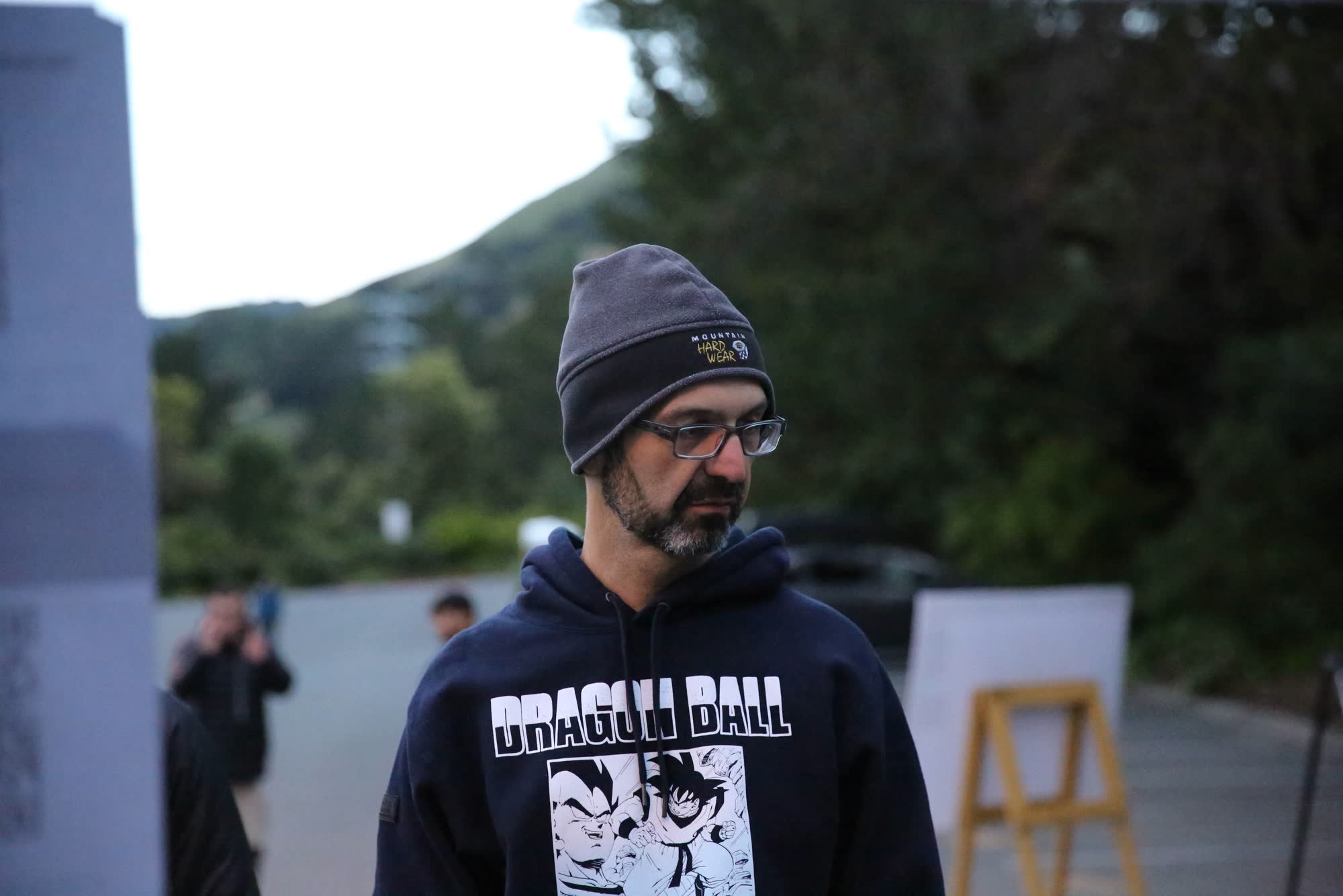 A volunteer in a beanie and hoodie standing at the race start area
